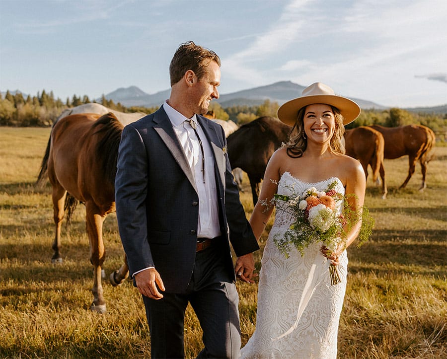 bride and groom out with horses for photoshoot