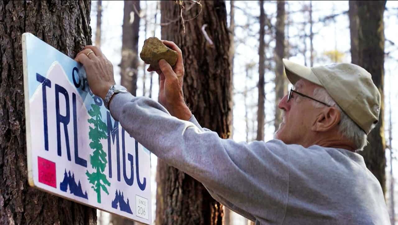 Man hanging up a trail magic sign on the PCT trail