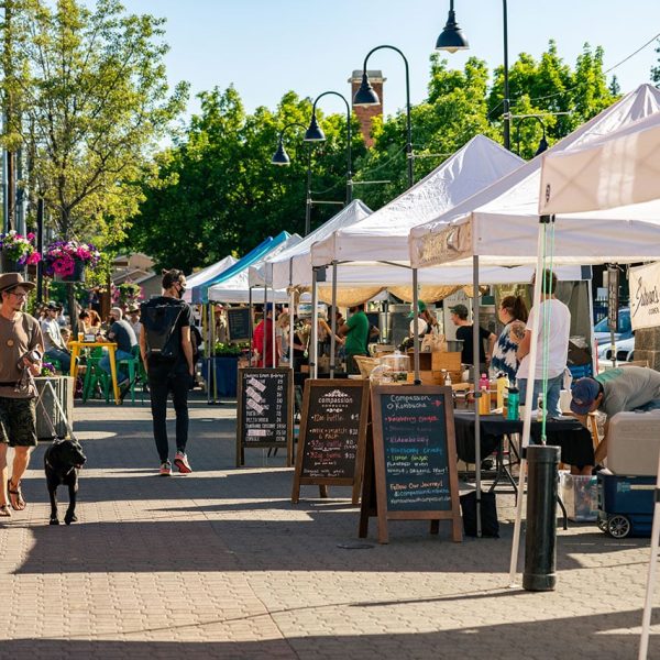 Man with dog walking at Bend Farmers Market
